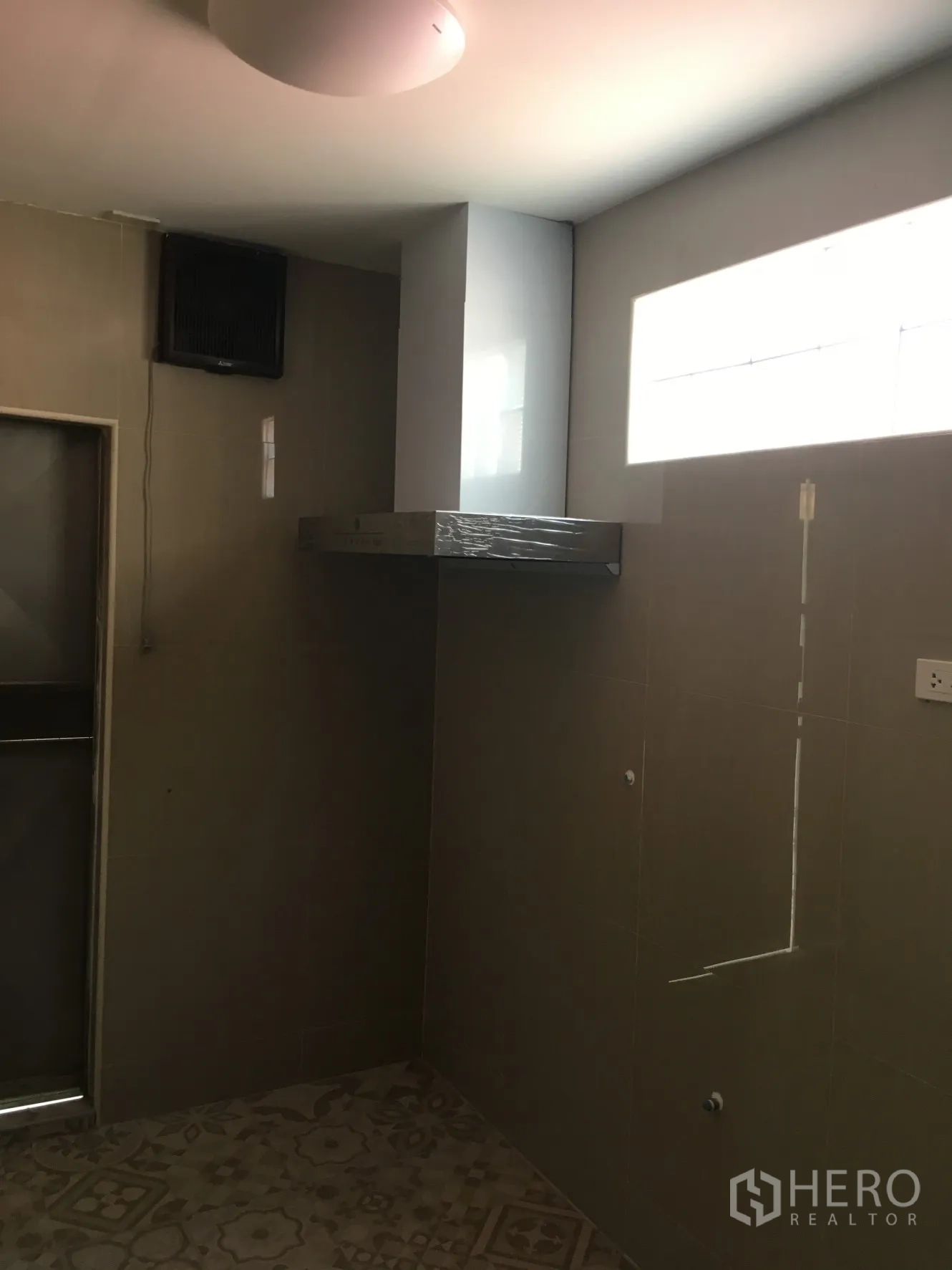 联排别墅 出租在Huai Khwang, Bangkok - 简约泰式厨房，墙面瓷砖、排烟机与花纹地砖。