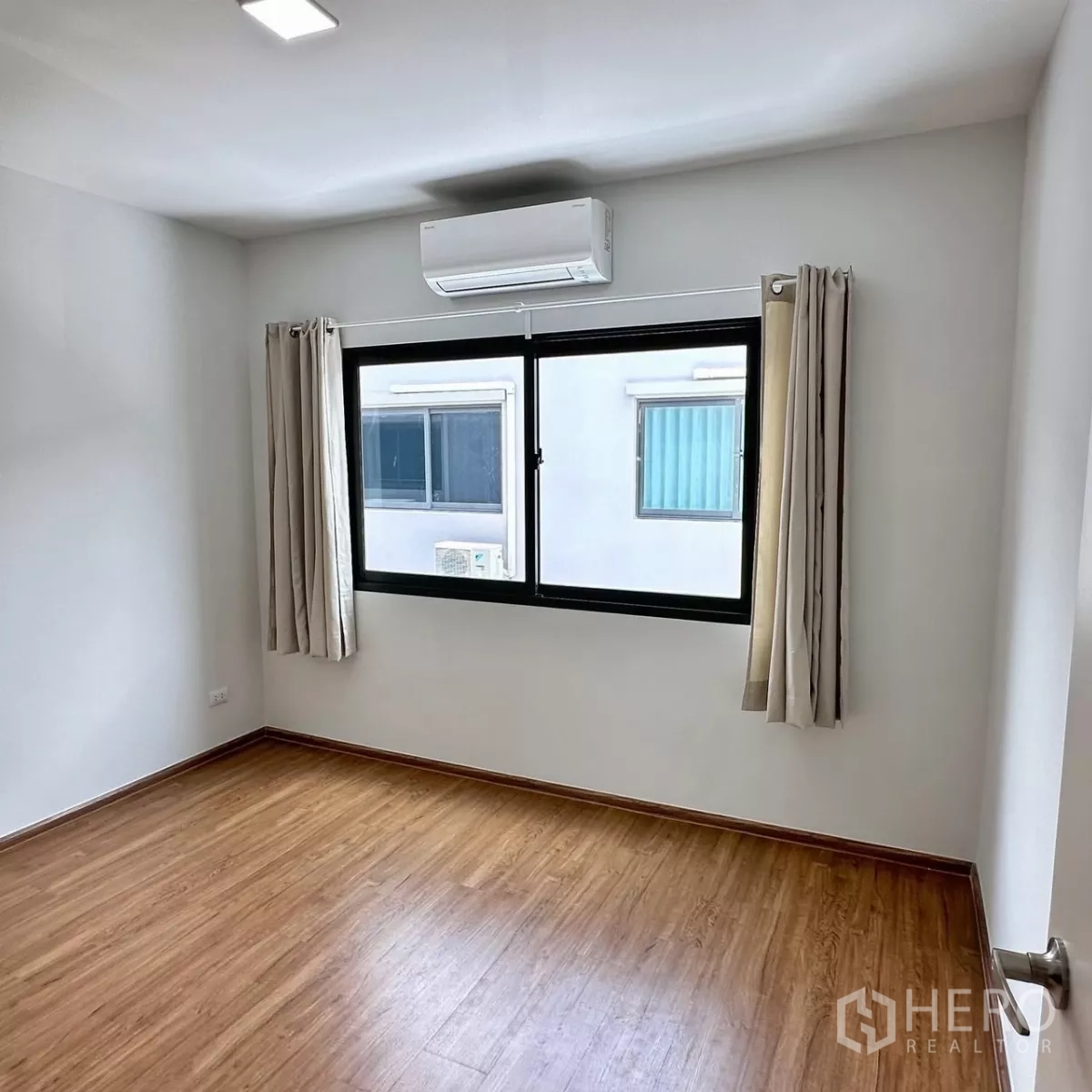 Townhouse for rent in Bang Phli, Samut Prakan - Bedroom corner with round mirror, floating vanity shelf and glossy sliding wardrobe.