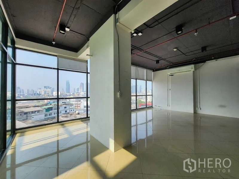 Office Space for rent in Yan Nawa, Bangkok - Open-plan office with central column, black exposed ceiling, and city views.