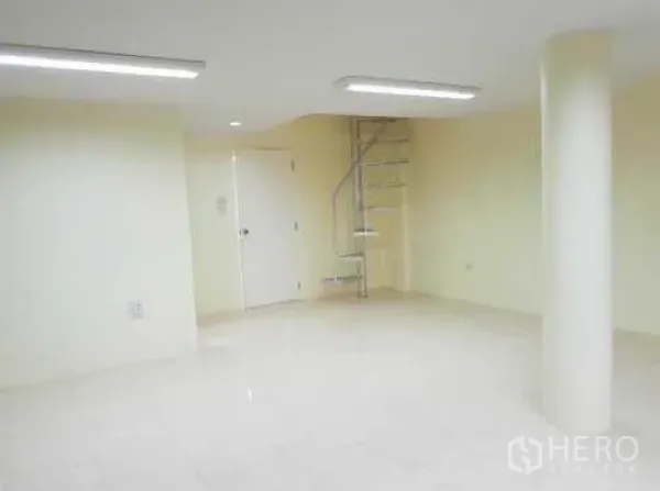 Townhouse for rent in Khlong Toei, Bangkok - Bright open room with a spiral staircase, round column and glossy tile floors.