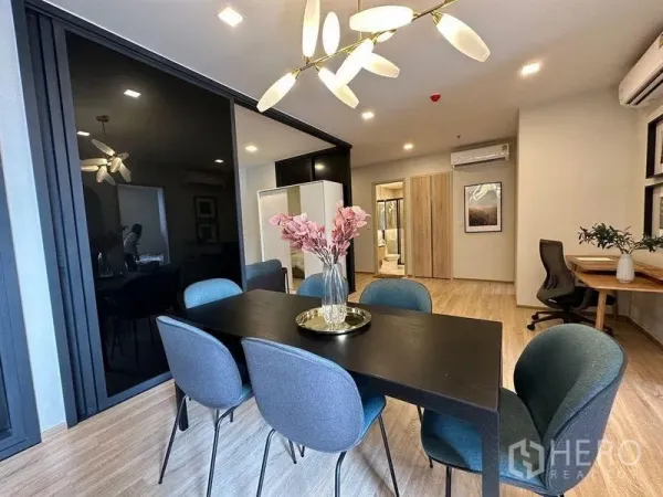 公寓 出租在Ratchathewi, Bangkok - 明亮餐区，六人餐桌、现代吊灯，旁有内置书桌。