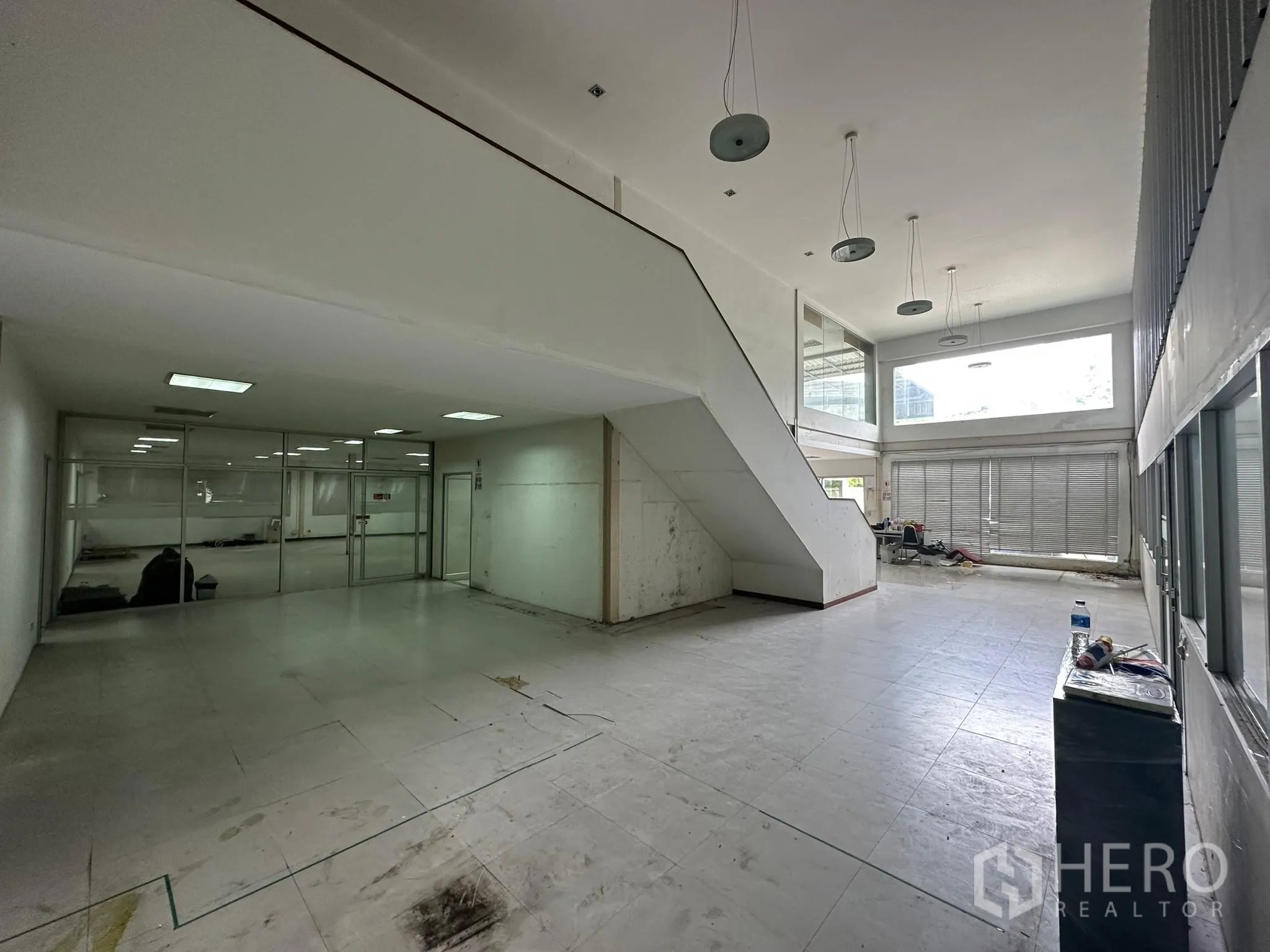 Warehouse for rent in Huai Khwang, Bangkok - Double-height reception hall with large windows and central staircase.