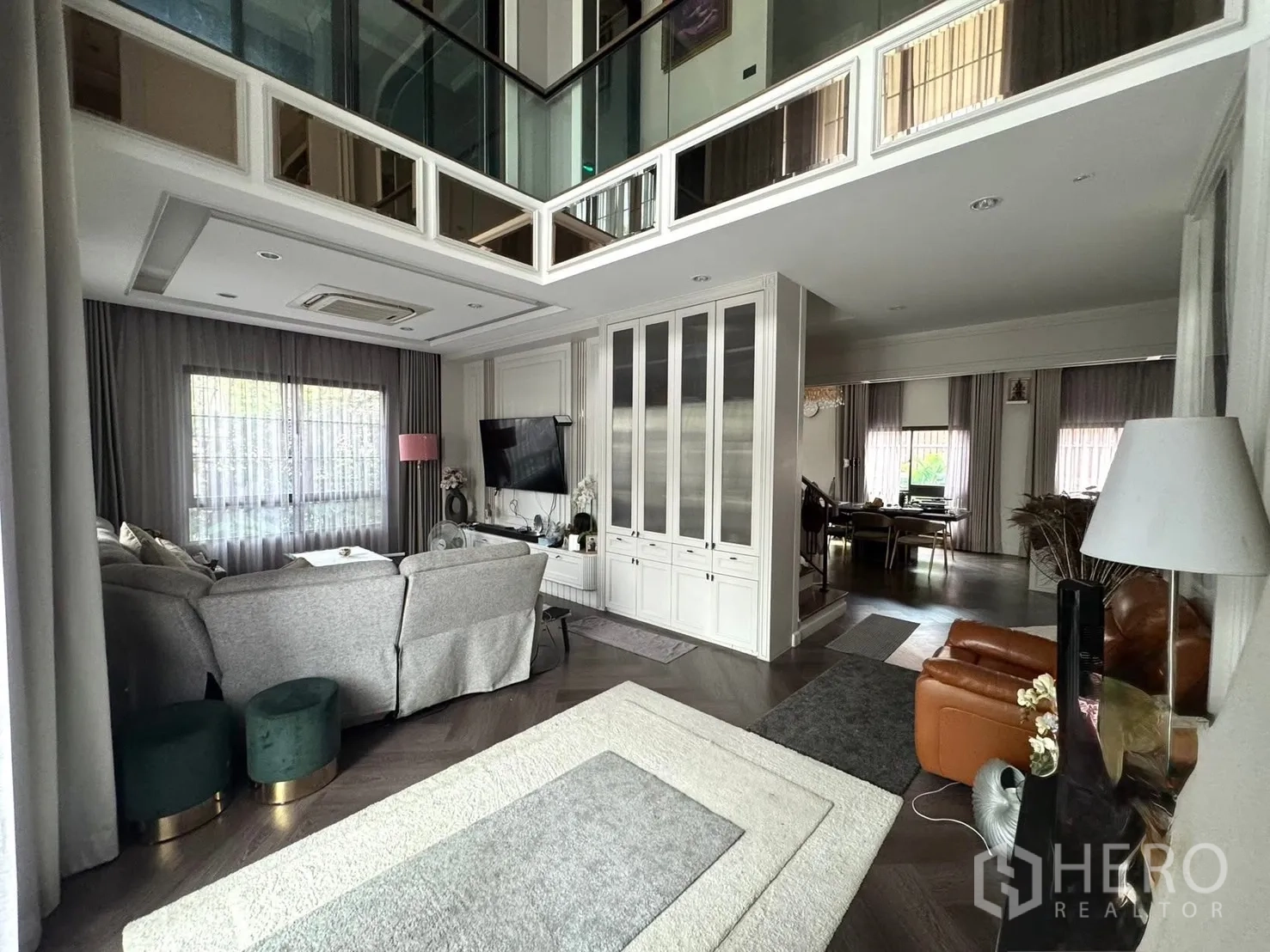 独立式住宅 出售在Mueang Pathum Thani, Pathum Thani - 起居区与餐厅相连，大窗与柔和窗帘。