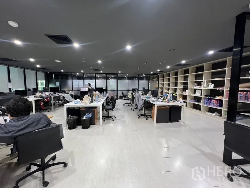 Office Space for rent in Watthana, Bangkok - Open-plan workspace with desks, frosted windows and wall-length shelving.