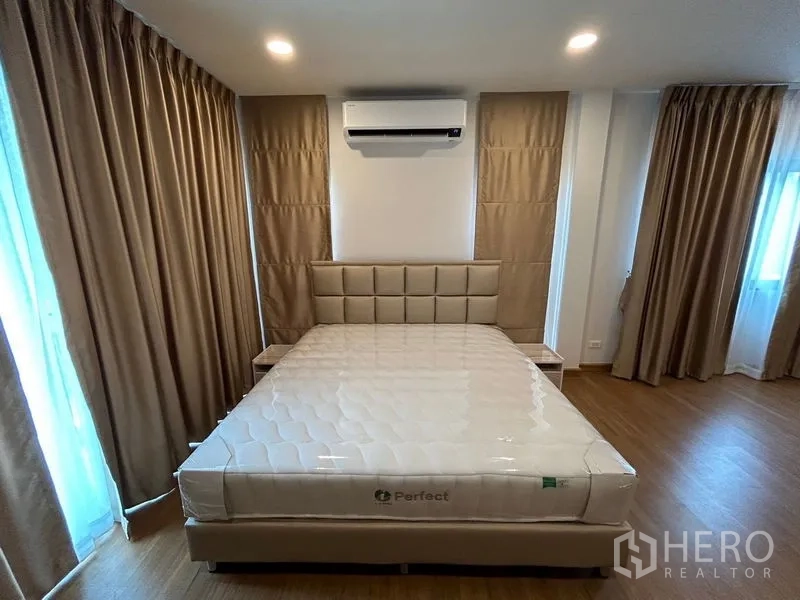Detached House for rent in Bang Phli, Samut Prakan - Master bedroom with upholstered bed, air conditioning, wood floor and full curtains.