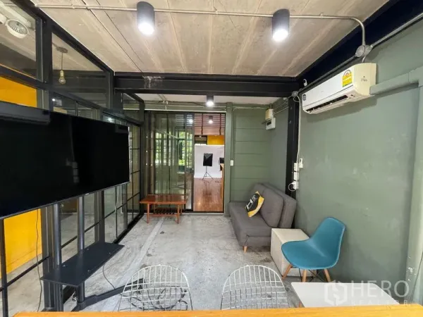 Home Office for sale - Glass-walled home office lounge with TV, sofa and air-conditioning in an industrial style.