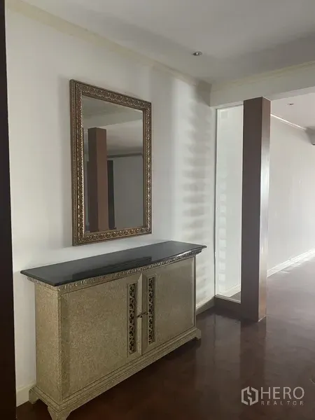 Condominium for rent or sale in Watthana, Bangkok - Hallway console with ornate framed mirror and decorative cabinet beside a partial glass divider.