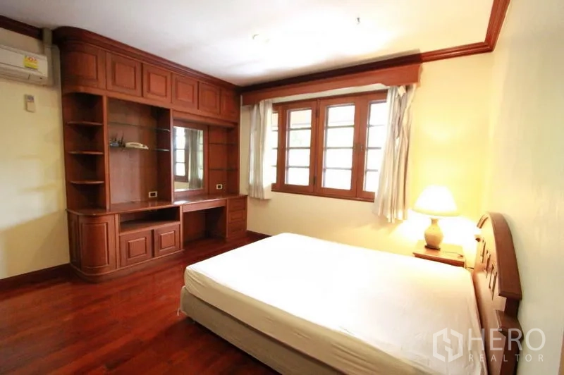 บ้าน ให้เช่าในPrawet, Bangkok - ห้องนอนพร้อมผนังบิลต์อินสื่อและโต๊ะทำงาน หน้าต่างสามบาน และพื้นไม้เงางาม