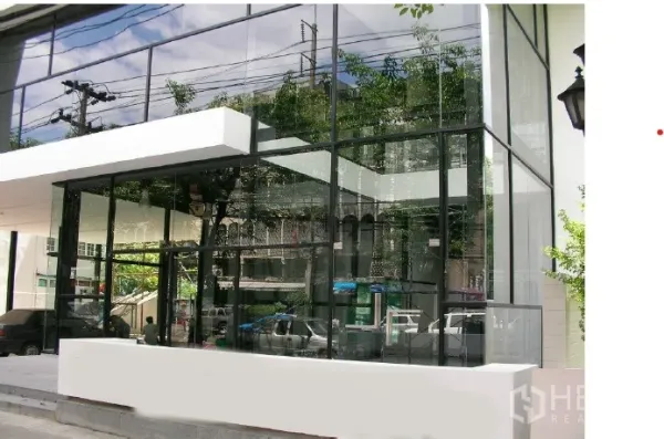 พื้นที่ขายปลีก ให้เช่า - ด้านหน้าร้านสมัยใหม่ กระจกใสเต็มบาน โครงสีดำ พร้อมกันสาดสีขาว สะท้อนทิวทัศน์ถนนเมือง