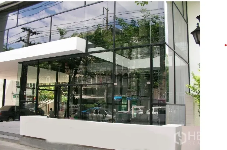 พื้นที่ขายปลีก ให้เช่า - ด้านหน้าร้านสมัยใหม่ กระจกใสเต็มบาน โครงสีดำ พร้อมกันสาดสีขาว สะท้อนทิวทัศน์ถนนเมือง