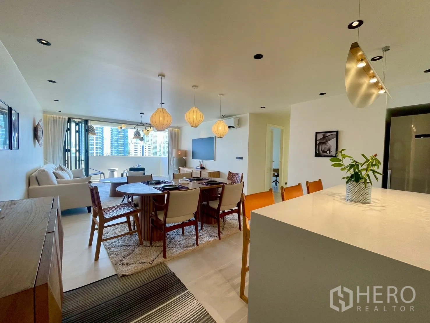 Condominium for sale in Watthana, Bangkok - Open living space connecting dining area and kitchen, leading to a balcony with views.