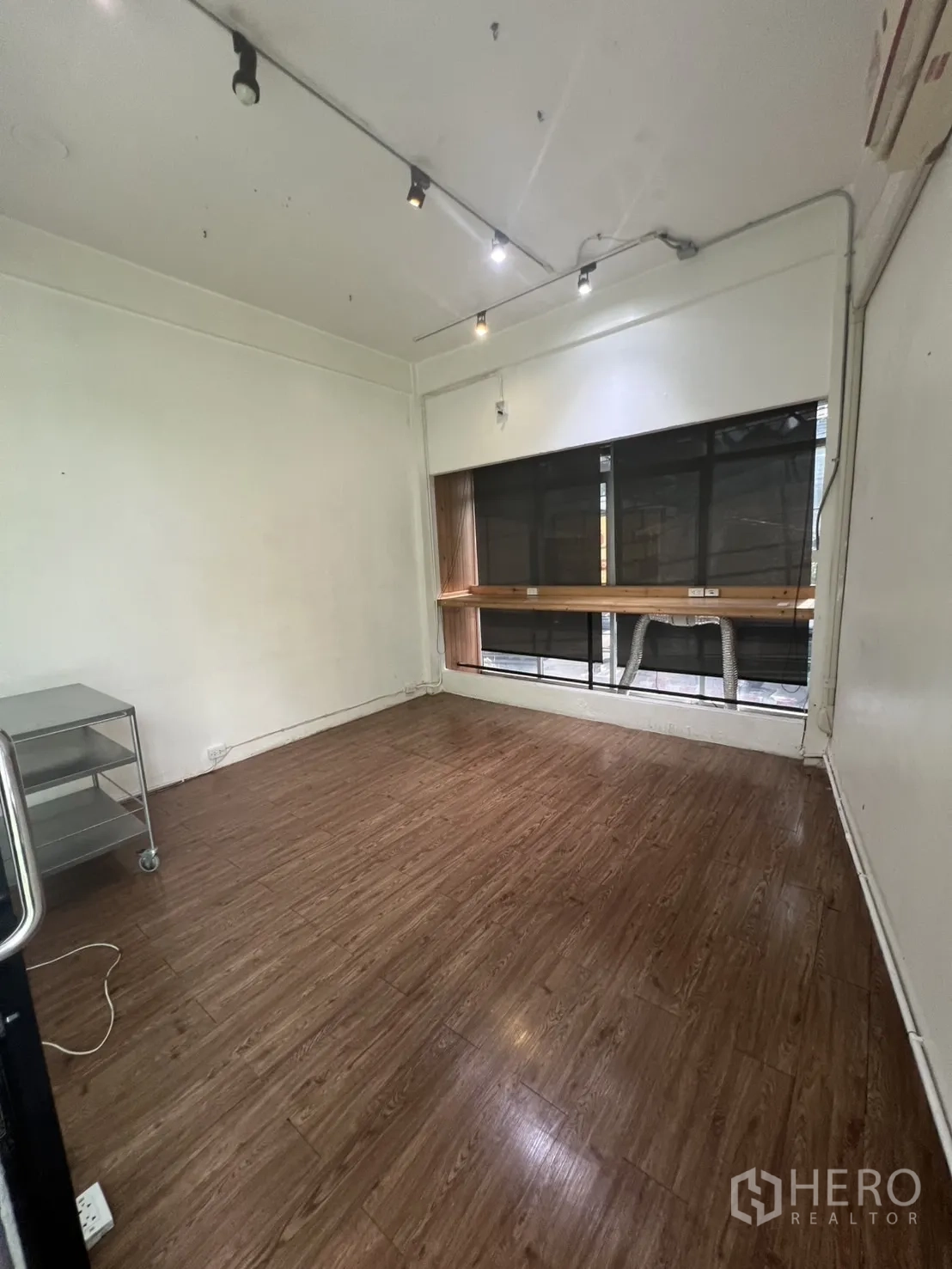 零售空间 出租在Watthana, Bangkok - 小型房间，木纹地板与射灯，窗前设吧台。