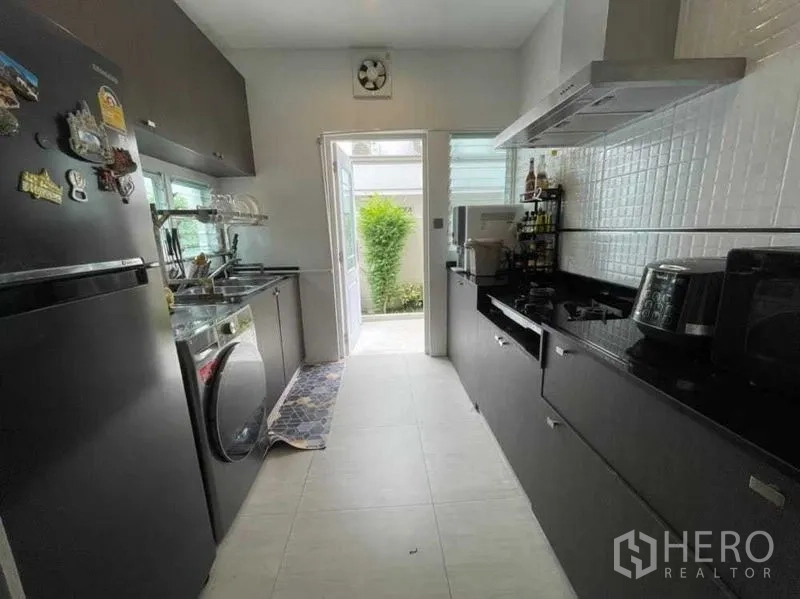 独立式住宅 出租在Bang Khen, Bangkok - 独立中厨，长操作台与燃气灶，门通向后院。