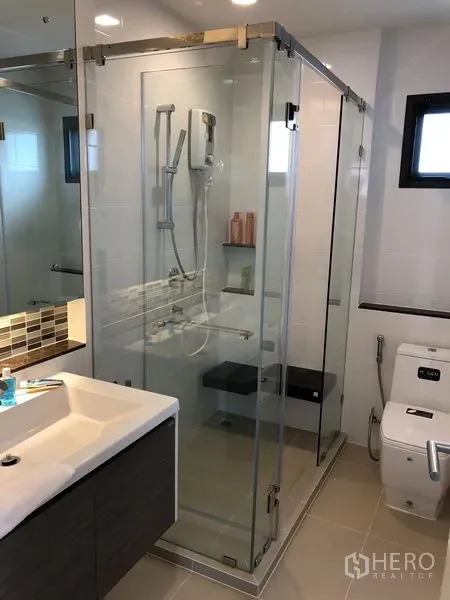 Detached House for rent in Bang Kapi, Bangkok - Contemporary bathroom featuring a glass-enclosed shower, vanity and toilet.