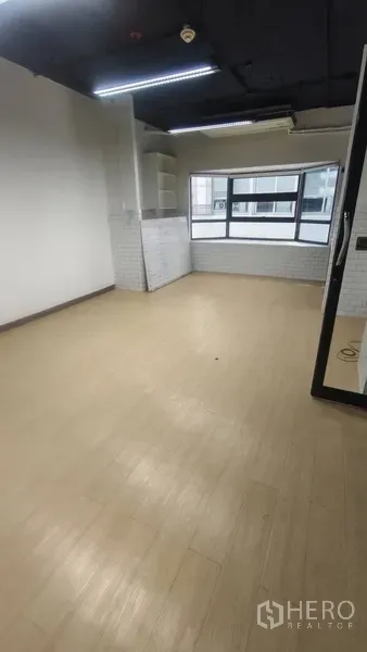 办公空间 出租在Pathum Wan, Bangkok - 采光充足的工作间，浅色木纹地板，大窗与内置搁架。