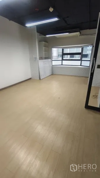 办公空间 出租在Pathum Wan, Bangkok - 采光充足的工作间，浅色木纹地板，大窗与内置搁架。