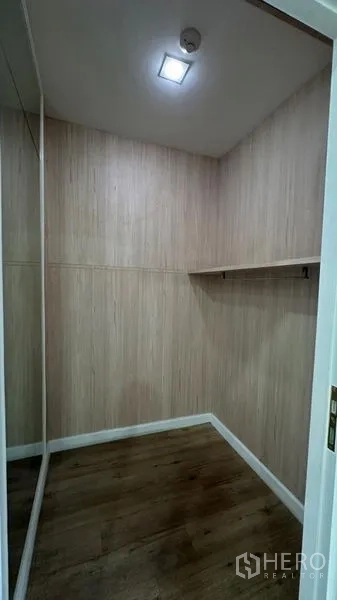 零售空间 出租 - 木纹墙面的次级储物间，带置物架与木地板。