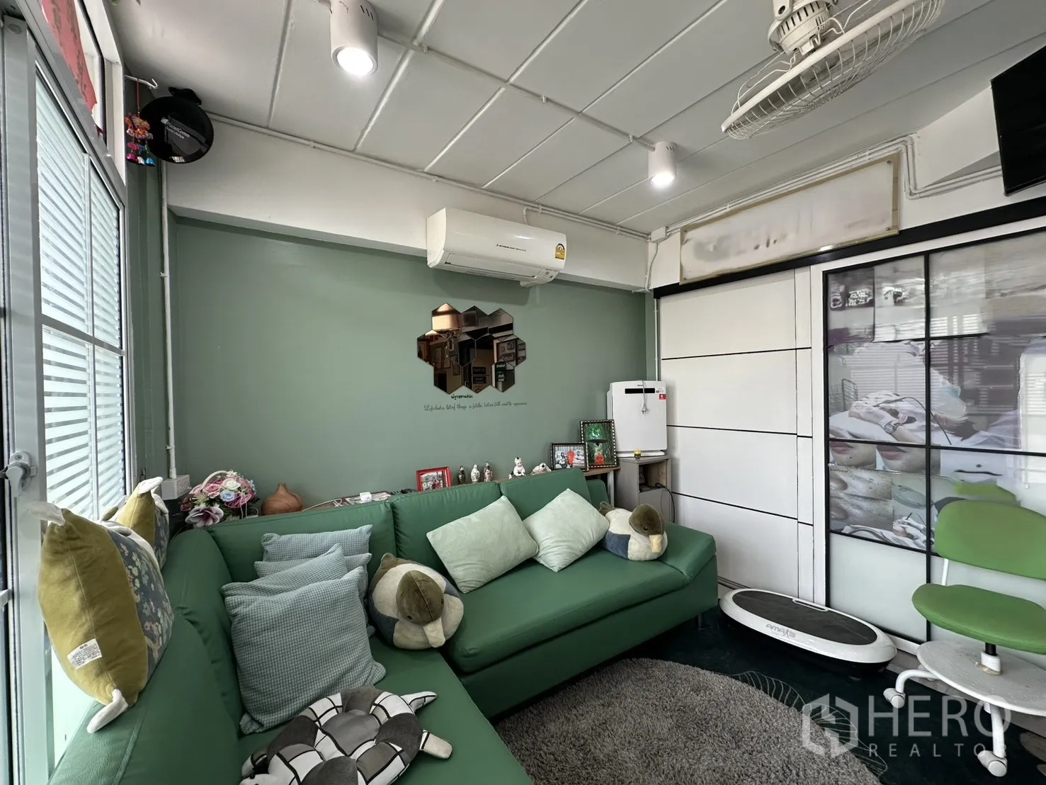 店屋 for rent in Phra Khanong, Bangkok - 室内客厅配绿色转角沙发、空调和推拉门。