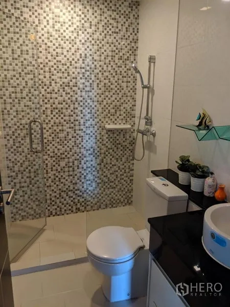 Condominium for rent in Watthana, Bangkok - Contemporary bathroom with glass-enclosed shower, mosaic wall tiles, vanity and toilet.