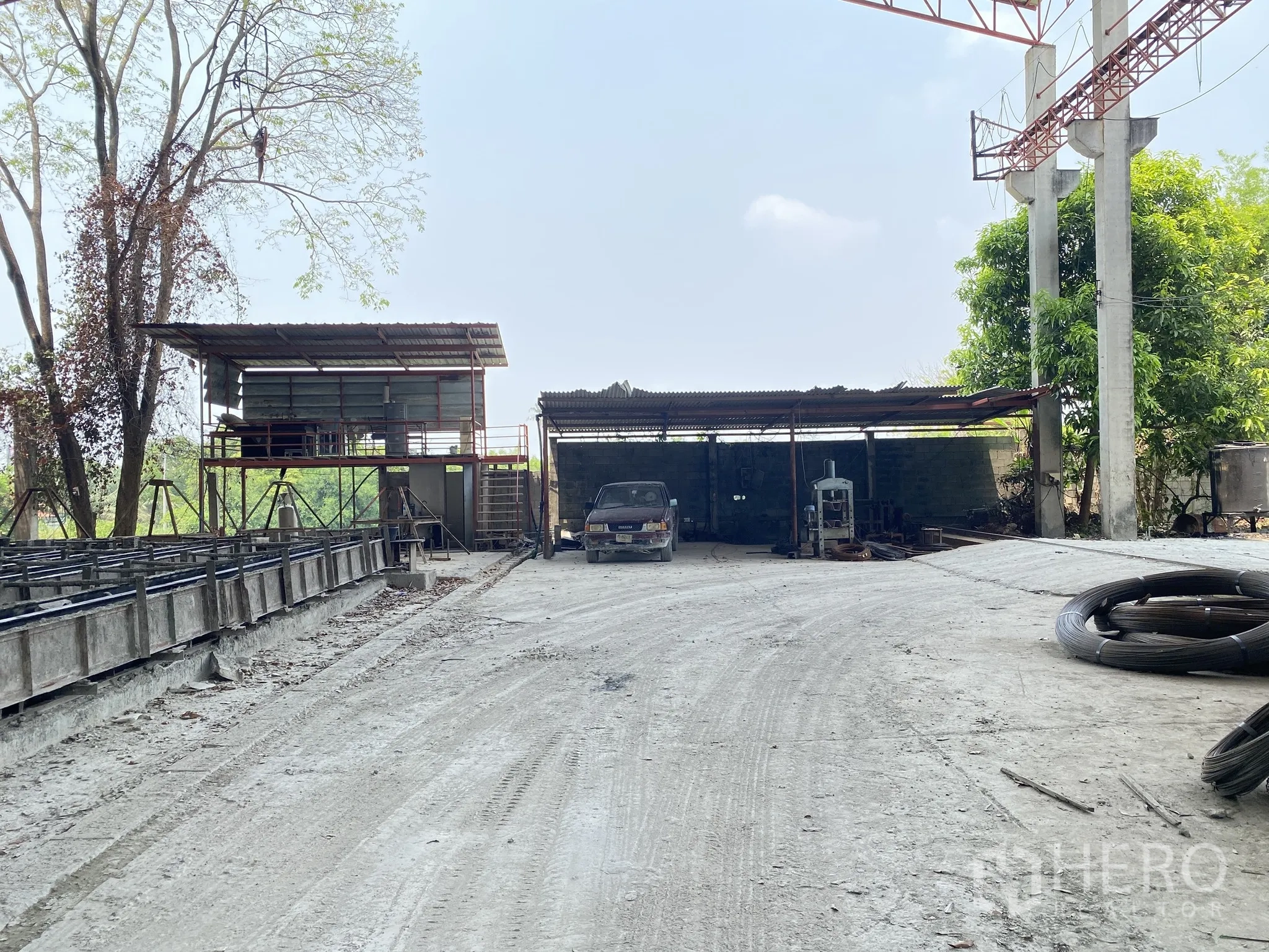 Factory for sale in Mueang Chon Buri, Chon Buri - Workshop area with small sheds, parked vehicle and equipment.