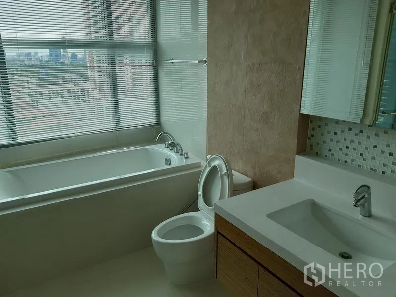 คอนโด ให้เช่าหรือขายในKhlong Toei, Bangkok - ห้องน้ำมีอ่างอาบน้ำติดหน้าต่างบานยาว โถสุขภัณฑ์ และเคาน์เตอร์อ่างล้างหน้า