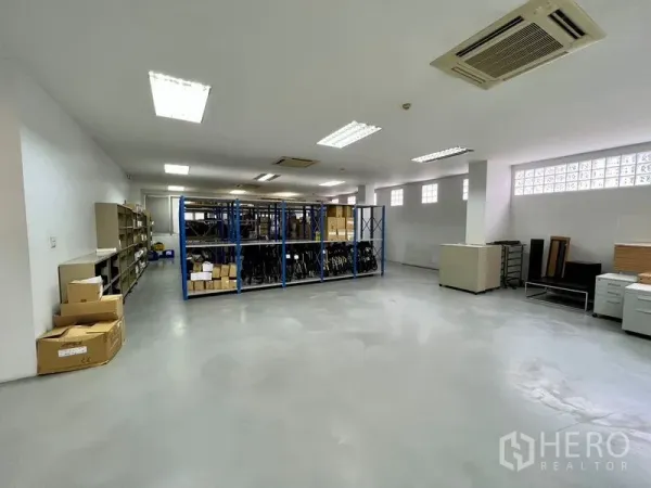 Office Space for rent in Bueng Kum, Bangkok - Spacious open-plan storage or office area with blue metal shelving, bright fluorescent lighting, and polished concrete floor.