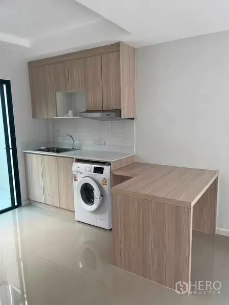 ทาวน์เฮาส์ ให้เช่าในSuan Luang, Bangkok - แพนทรีครัวโทนไม้สว่าง มีก็อกล้างจาน เตาเคาน์เตอร์ โต๊ะคาบิ้น และเครื่องซักผ้า