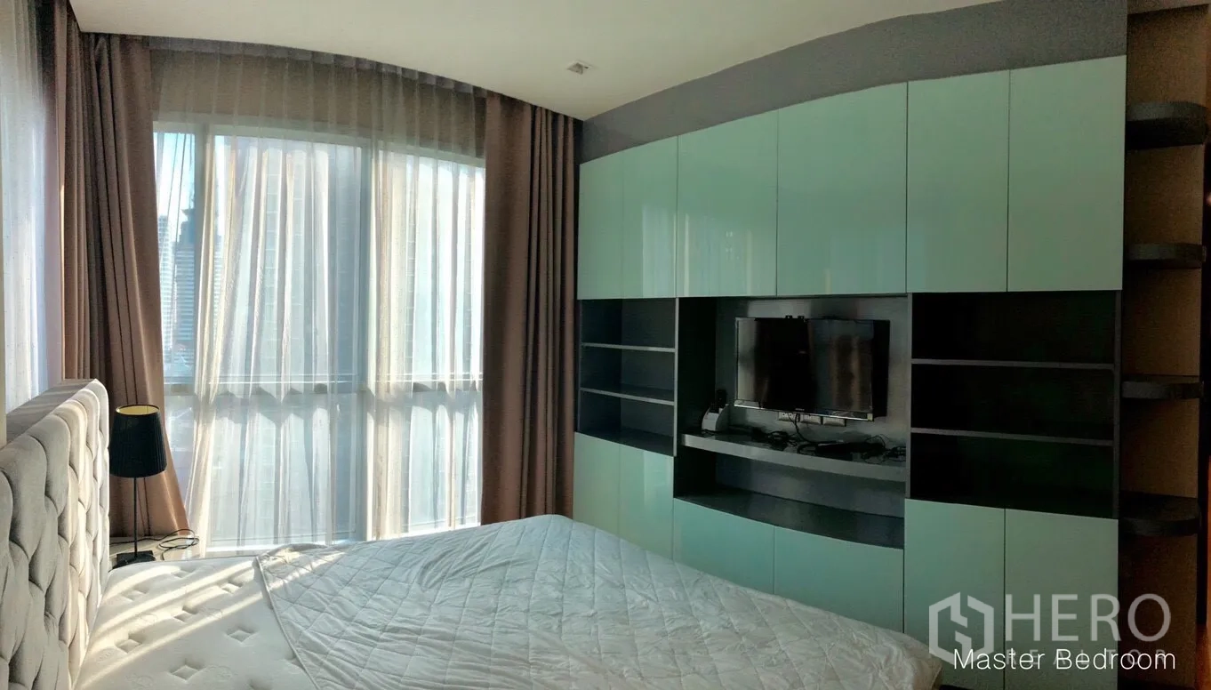 公寓 出租或出售在Ratchathewi, Bangkok - 主卧配大窗与纱帘，内置电视墙及多功能储物柜。