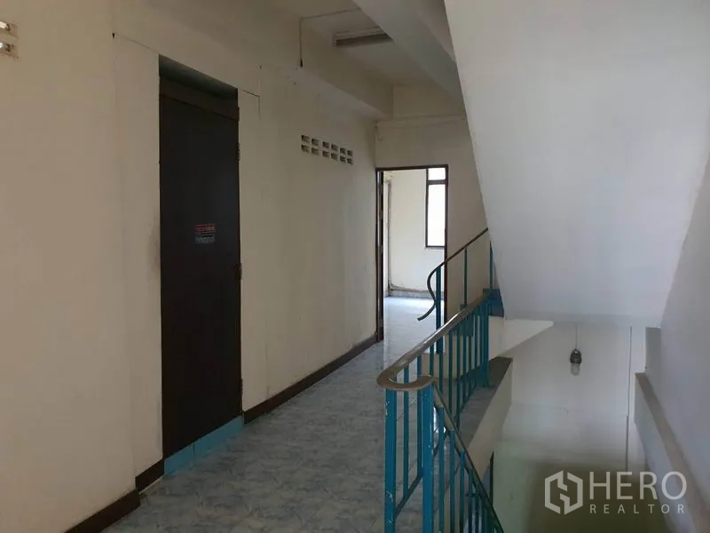 Shophouse for rent in Bang Rak, Bangkok - Hallway landing with blue railing connecting multiple rooms on the upper floor.