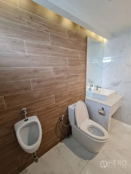 办公空间 出租在Bang Rak, Bangkok - 现代卫浴，木纹墙砖、坐便器、小便斗与石材台盆。