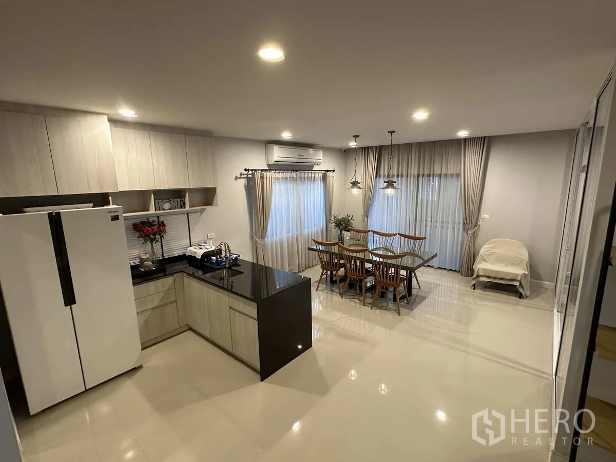 บ้าน ให้เช่าหรือขายในLam Luk Ka, Pathum Thani - ครัวสไตล์ยุโรปแบบเปิด ชุดครัวรูปตัวแอล ท็อปหินสีดำ และพื้นที่ทานอาหาร.