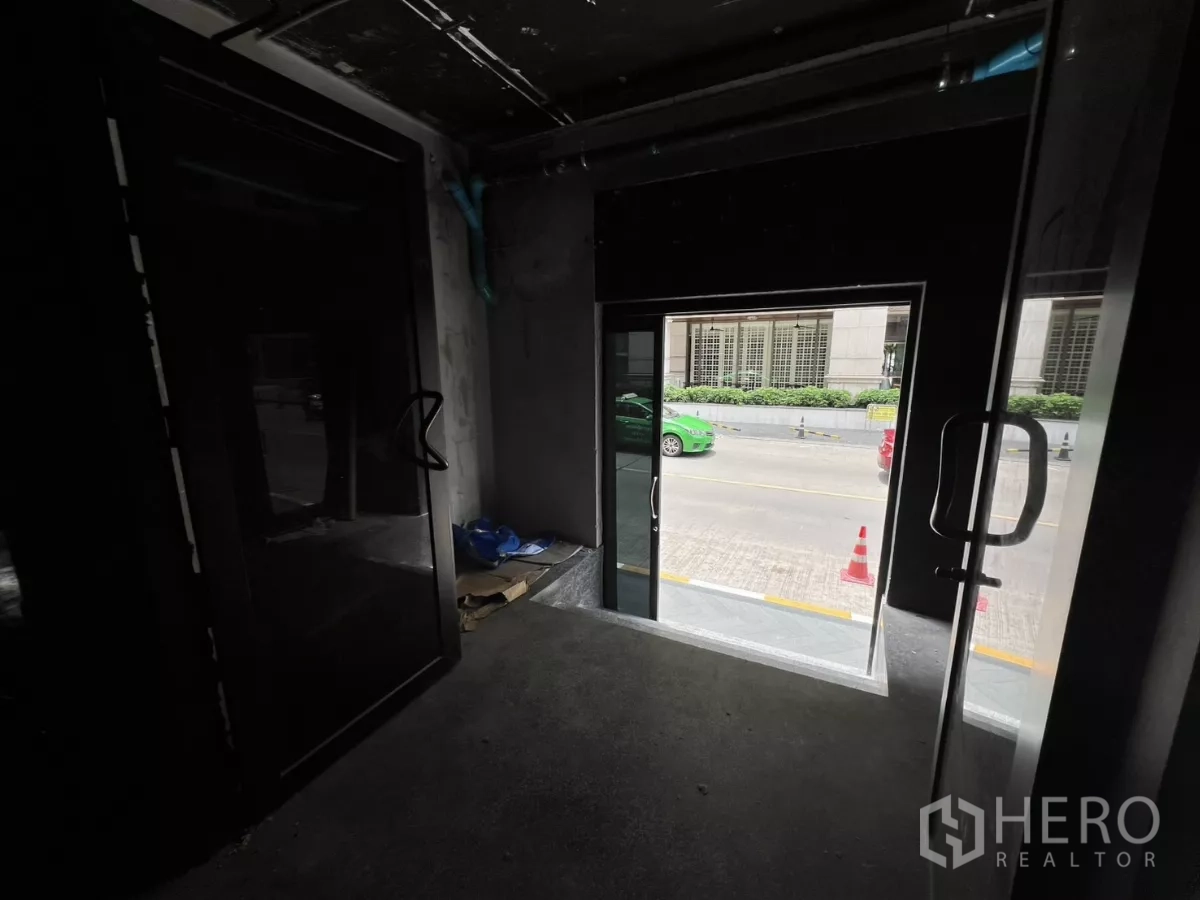 零售空间 出租在Khlong Toei, Bangkok - 从室内望向玻璃双开门，外接人行道与车道。