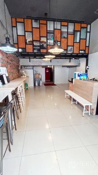 零售空间 出租在Watthana, Bangkok - 带夹层储物的商铺，高挑层天花、吊灯与沿墙吧台座位。