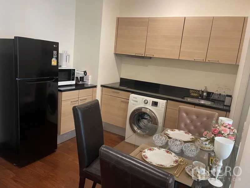 คอนโด ให้เช่าหรือขายในPathum Wan, Bangkok - ครัวกะทัดรัดตู้ไม้ เคาน์เตอร์หินสีดำ ตู้เย็น เครื่องซักผ้า และโต๊ะทานอาหาร