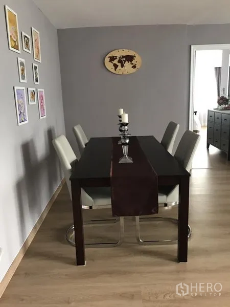 公寓 出租在Bang Rak, Bangkok - 用餐区，深色餐桌配四把椅子，墙面装饰画与中性色墙面。
