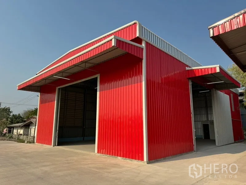 货栈 出租在Lam Luk Ka, Pathum Thani - 鲜红仓库外角，装卸雨棚与宽敞车道。