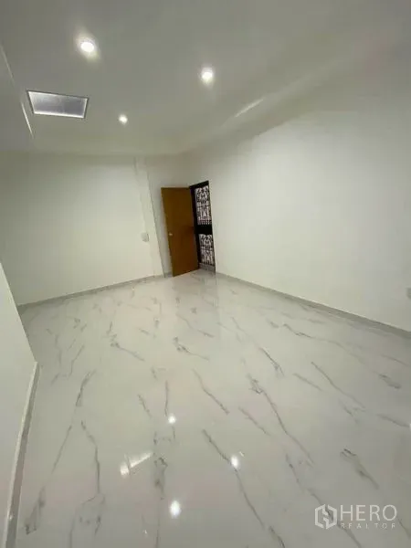 Detached House for rent in Huai Khwang, Bangkok - Empty room with recessed lighting and marble-look tiles.