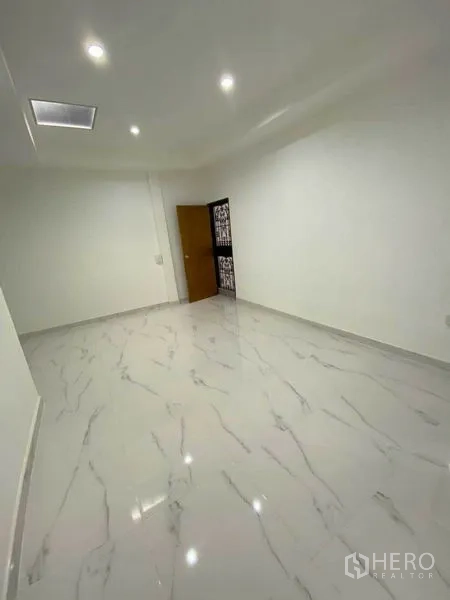 Detached House for rent in Huai Khwang, Bangkok - Empty room with recessed lighting and marble-look tiles.