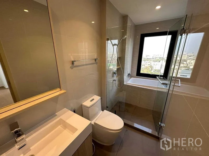 公寓 出售 - 现代浴室，玻璃淋浴间、浴缸与带景观的窗户。