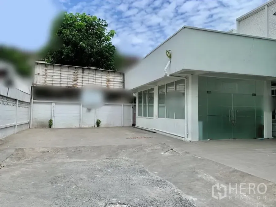 พื้นที่ขายปลีก ให้เช่าในKhlong Toei, Bangkok - อาคารพาณิชย์ชั้นเดียวโทนสีขาว หน้ากระจกบานคู่ พร้อมลานคอนกรีตกว้างสำหรับจอดรถและขนส่ง