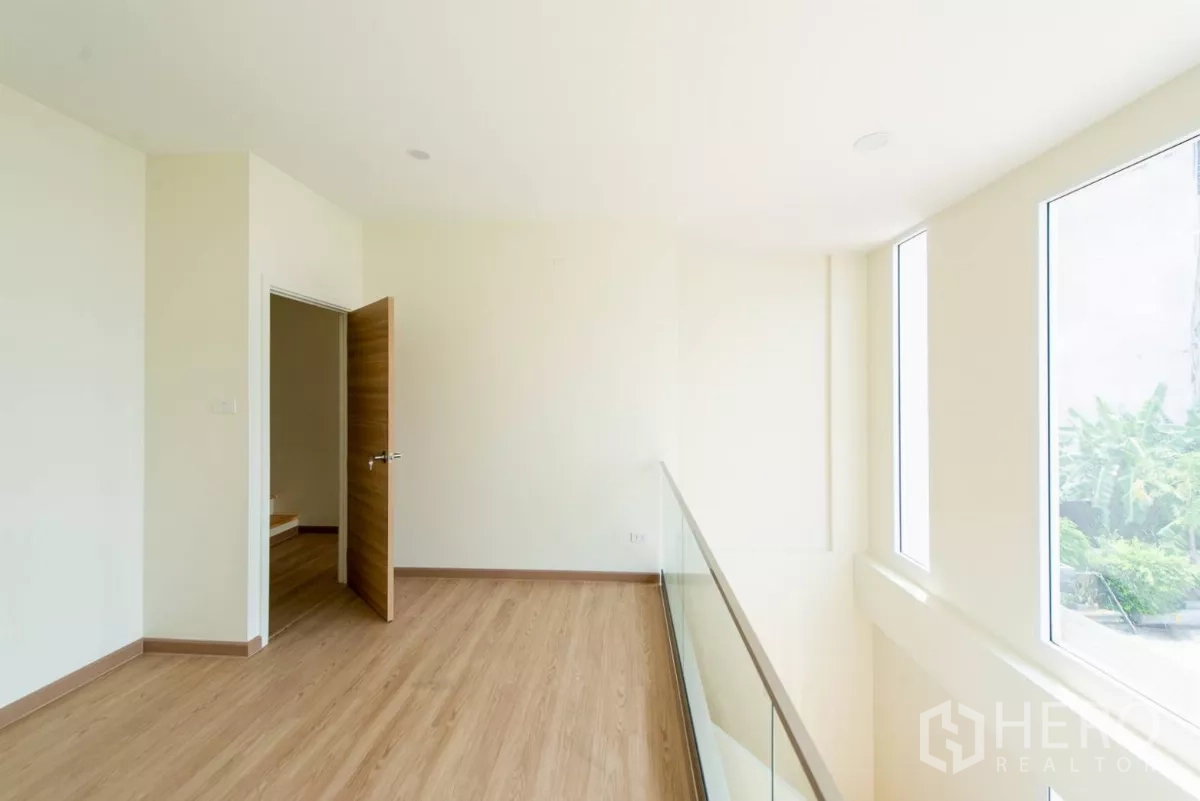 联排别墅 出售在Lat Phrao, Bangkok - 夹层走廊，玻璃栏杆俯瞰挑高客厅