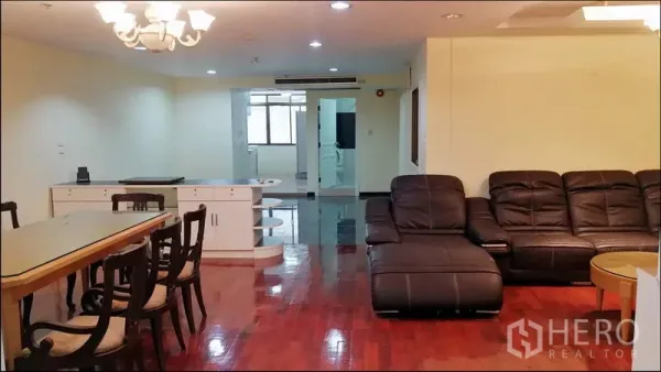 公寓 出租或出售在Khlong Toei, Bangkok - 开放式客厅，枝形吊灯、L形沙发与抛光木地板。