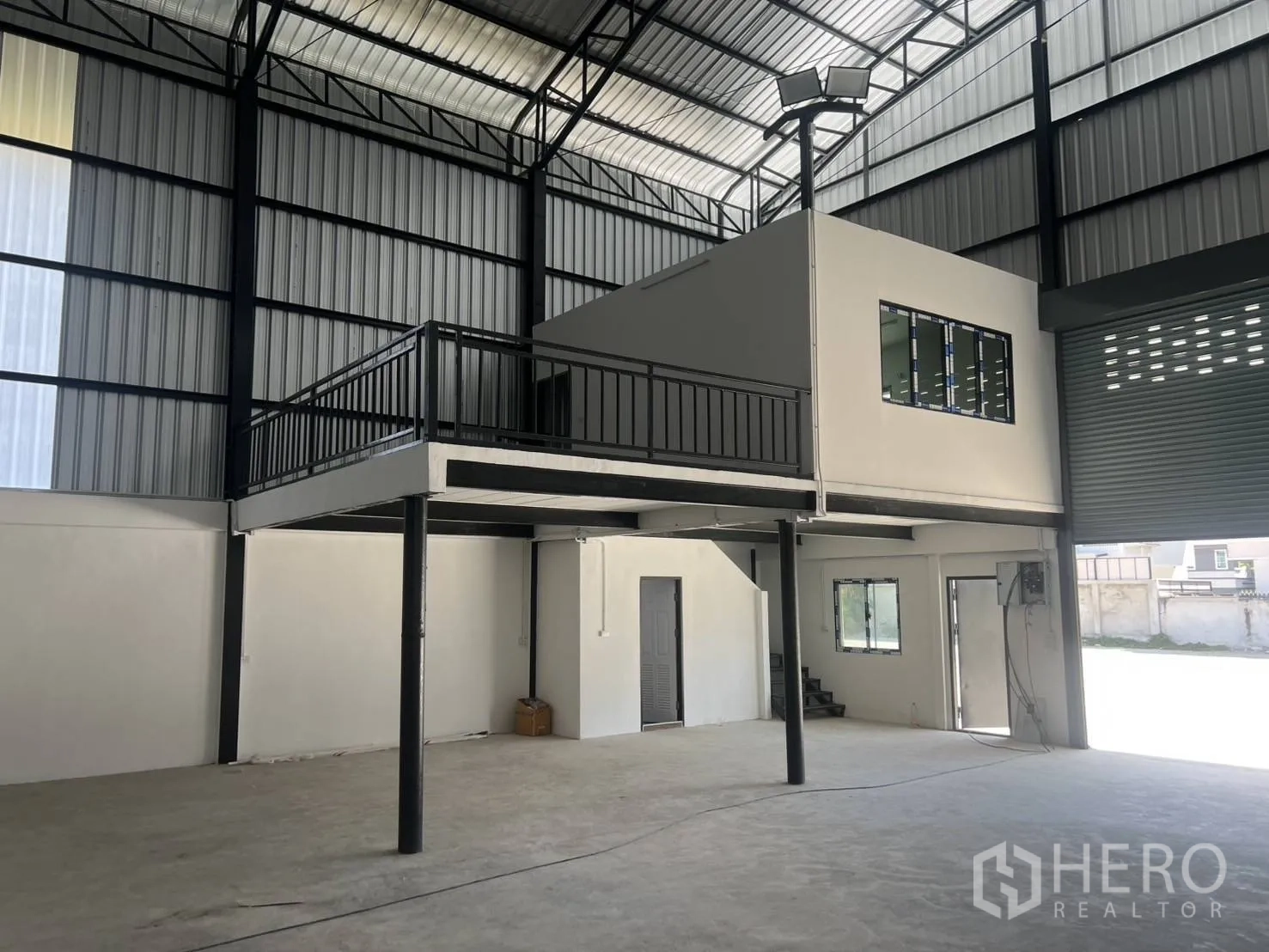 Warehouse for rent in Bang Phli, Samut Prakan - Angled shot of mezzanine platform with railing and office above, overlooking the open warehouse floor.