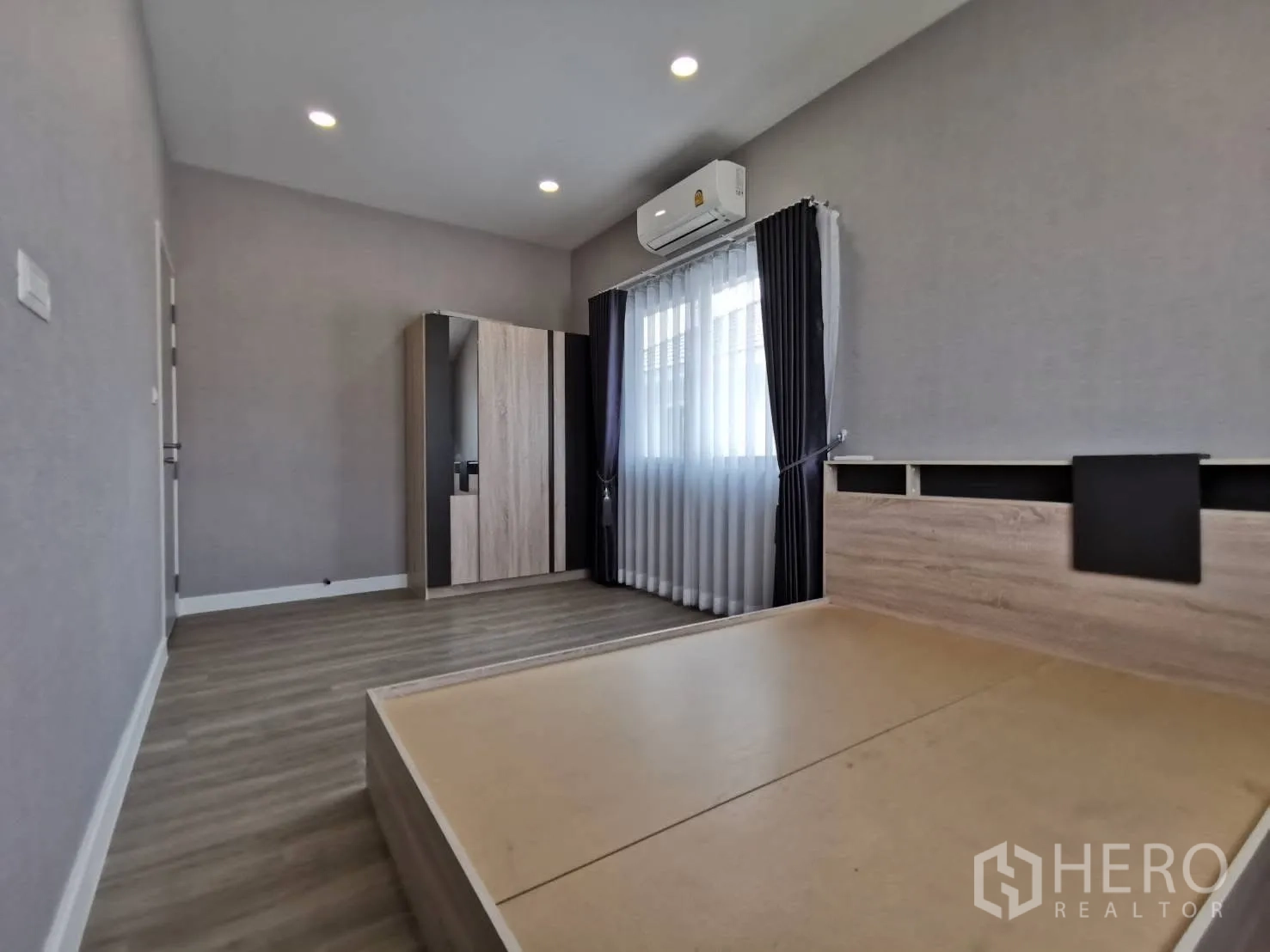 Detached House for rent in Bang Phli, Samut Prakan - Bedroom with built-in wardrobe, platform bed frame, gray walls, wood flooring, and air conditioning.