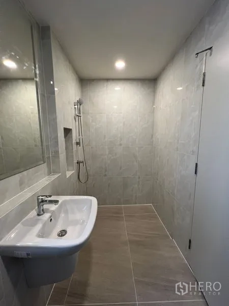 Detached House for rent or sale in Bang Phli, Samut Prakan - Bathroom with wall-mounted sink, mirror and walk-in shower.