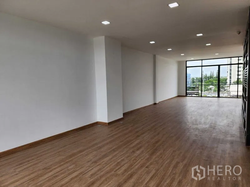 带办公室的家 出租在Prawet, Bangkok - 宽敞开放式楼层，木纹地板，嵌灯天花，整面落地窗可见城市景观。