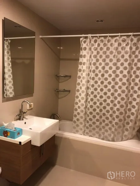 คอนโด ให้เช่าในKhlong San, Bangkok - ห้องน้ำสมัยใหม่พร้อมอ่างอาบน้ำ อ่างล้างหน้า กระจก และผ้าม่านอาบน้ำลายจุด