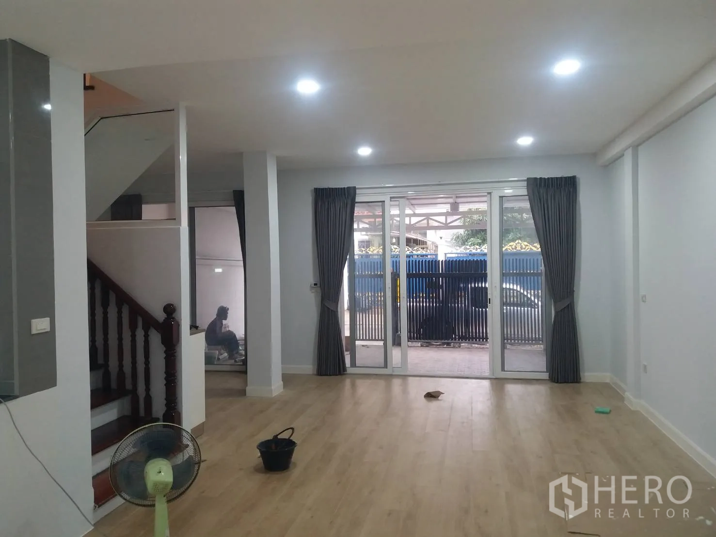 ทาวน์เฮาส์ ให้เช่าในKhlong Toei, Bangkok - ห้องนั่งเล่นโปร่งพื้นลามิเนตสีอ่อน ไฟดาวน์ไลท์ และประตูกระจกบานเลื่อน.