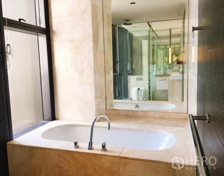 公寓 出租或出售在Sathon, Bangkok - 大理石浴室，内置浴缸与玻璃淋浴间和大镜面。