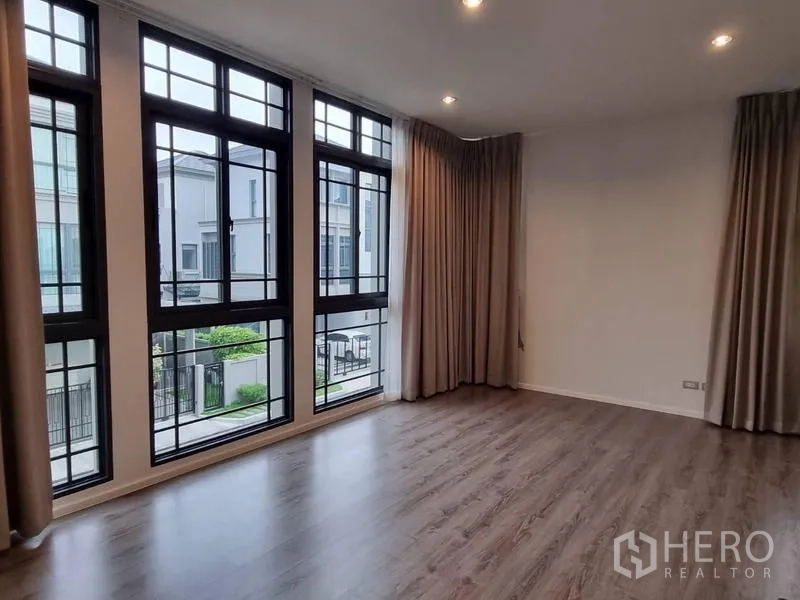 Detached House for rent - Upper-floor bedroom with full-height windows and curtains overlooking the street.